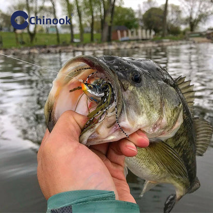 Angler holding a large bass caught using 13g metal jigs for fishing in a scenic waterway