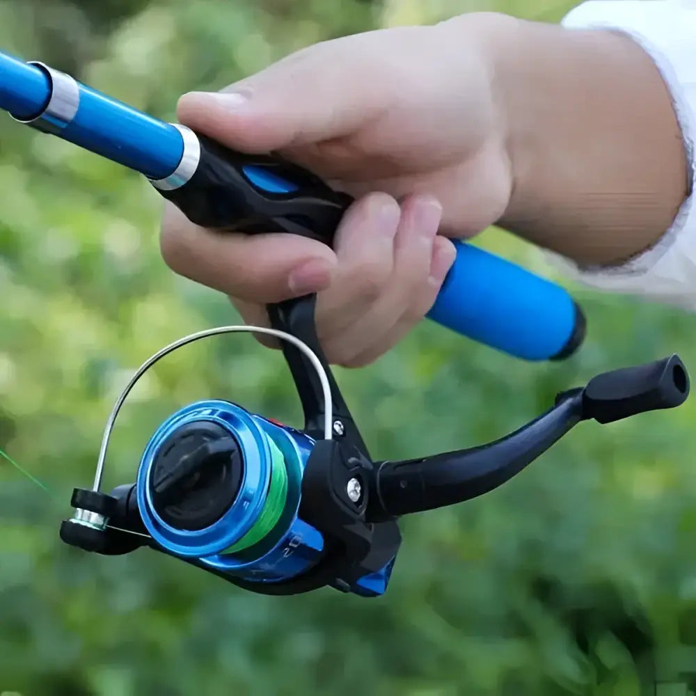 Hand holding a blue fishing reel attached to a fishing rod and tackle combo ready for use